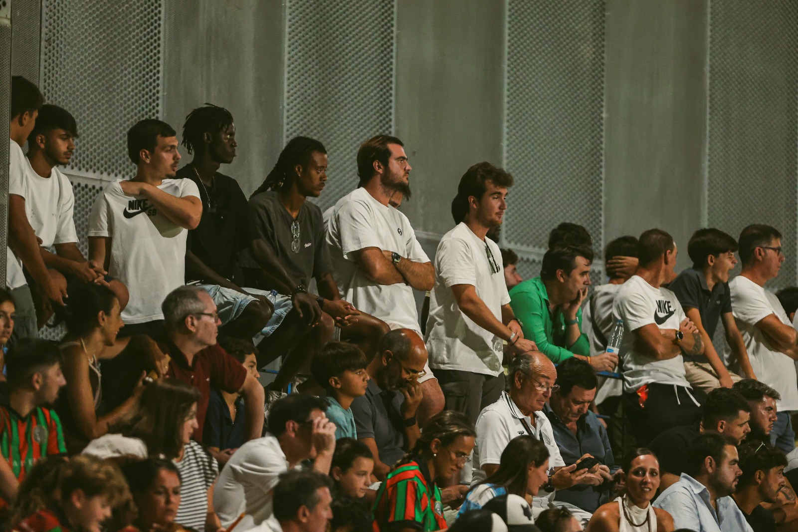 Aficionados siguiendo el partido de pie en la grada